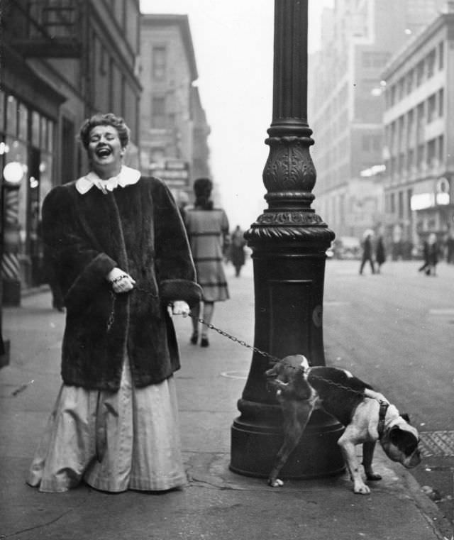Actress Joan Roberts, wearing a costume for the musical Oklahoma, walked her English bulldog Goggles during intermission, 1944.