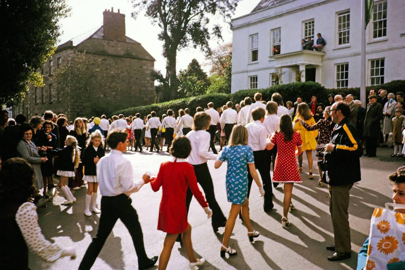 Couples walk hand in hand in procession for the Evening Dance, Flora Day