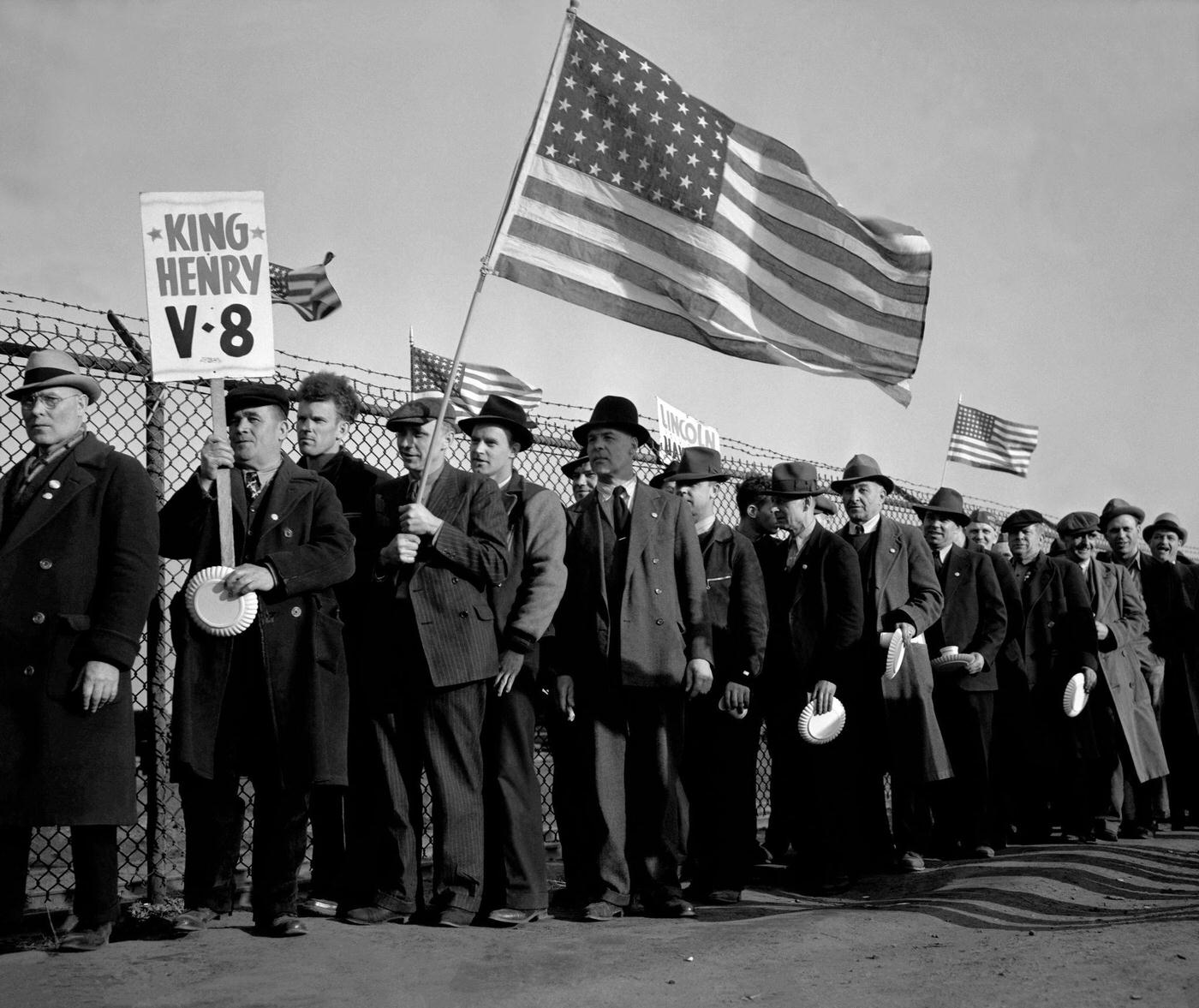 Workers from the Ford Motor Company hold American Flags near the River Rouge plant during the Detroit Ford Labor strike in Dearborn, Michigan, April 11, 1941.