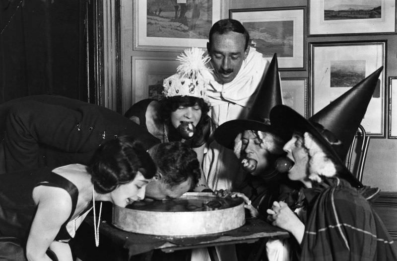 These witches are bobbing for apples at a fancy Halloween party in 1922.