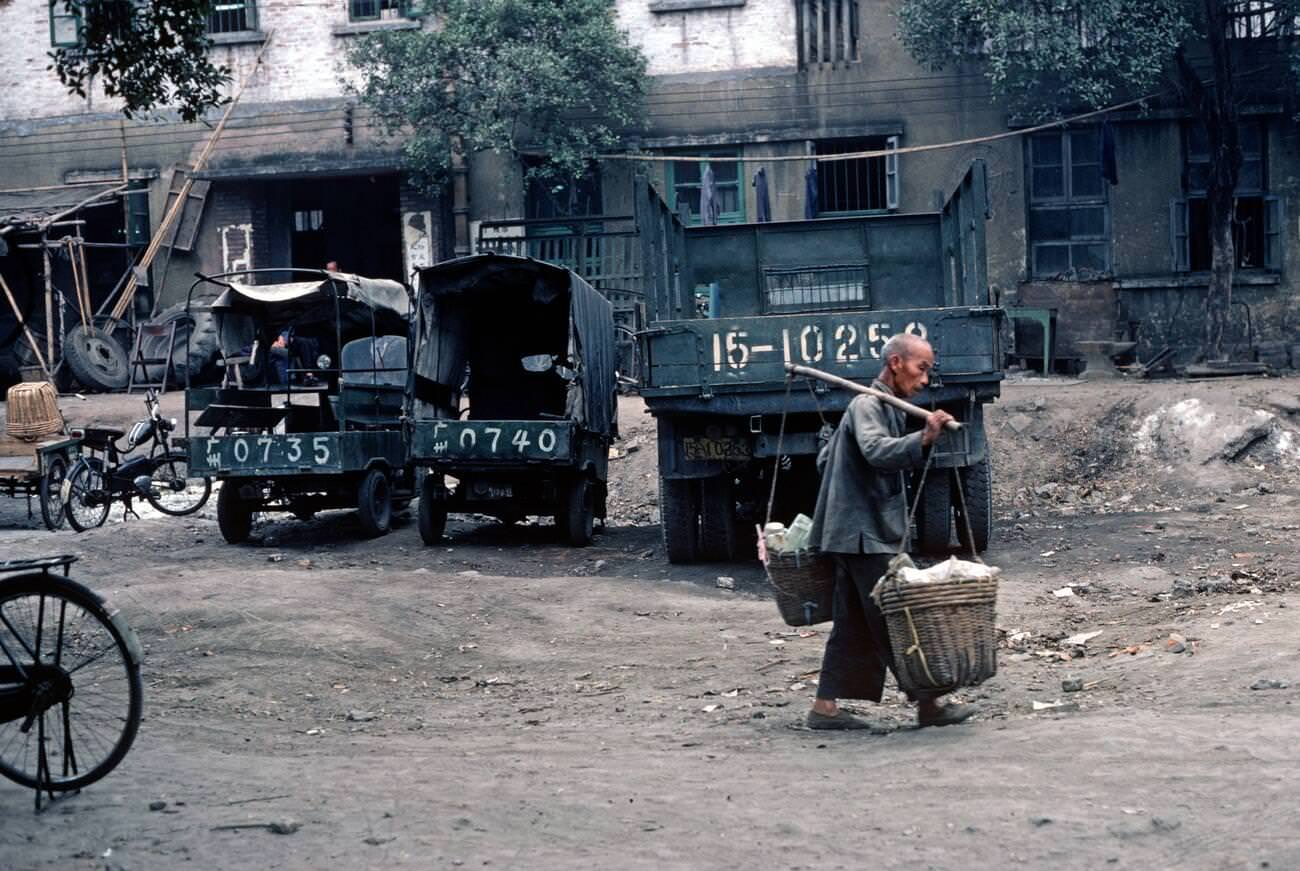 man carrying baskets on bamboo pole, outside Guangzhou, China, 1980