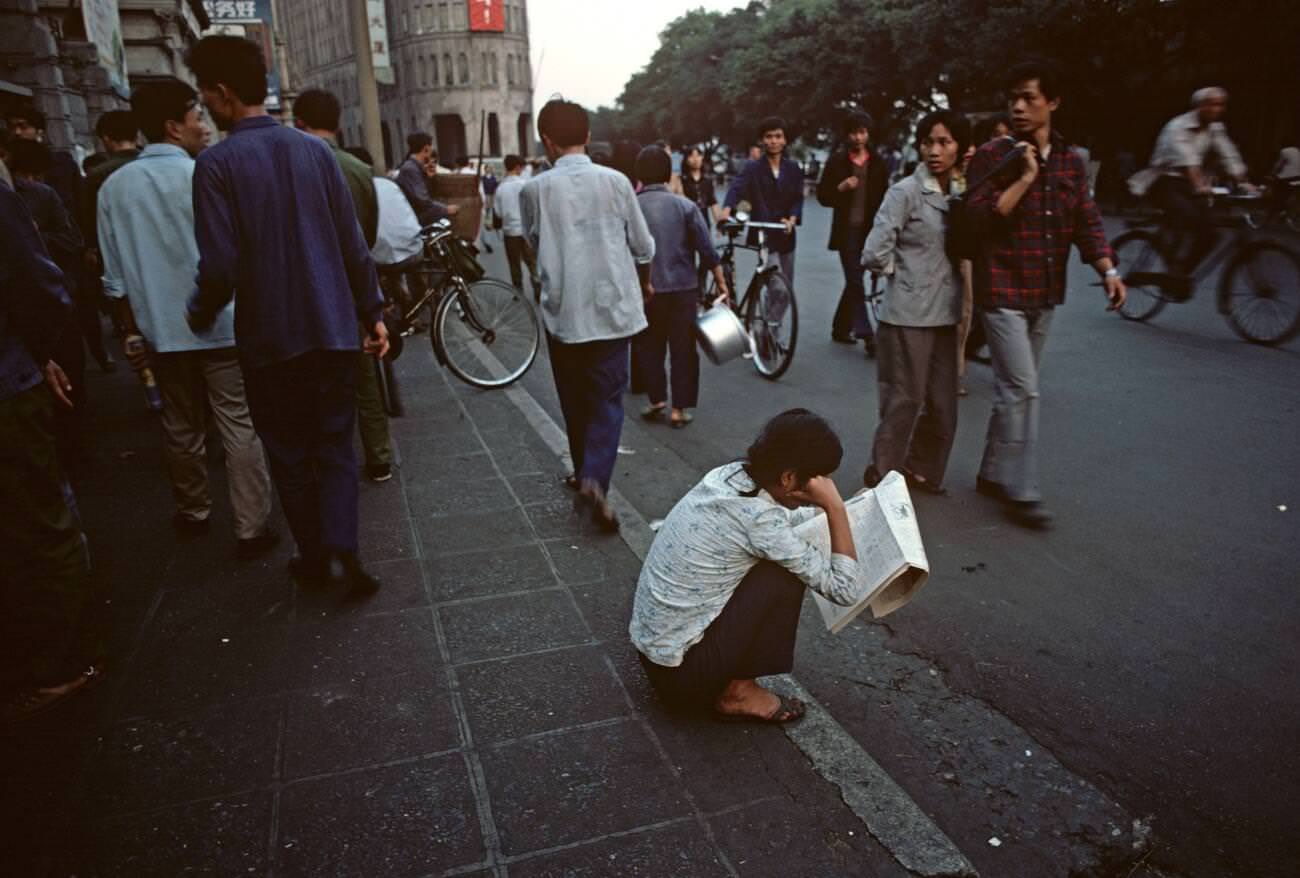 reading newspaper in Guangzhou street, China, 1980