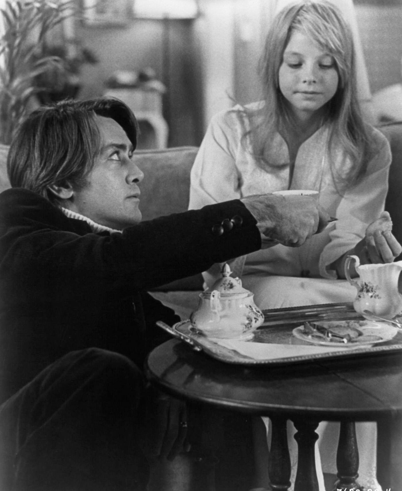 Martin Sheen holding a tea cup in front of Jodie Foster in 'The Little Girl Who Lives Down The Lane', 1976.