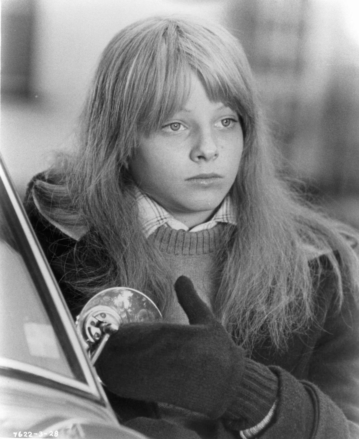 Jodie Foster standing beside a car in 'The Little Girl Who Lives Down The Lane', 1976.