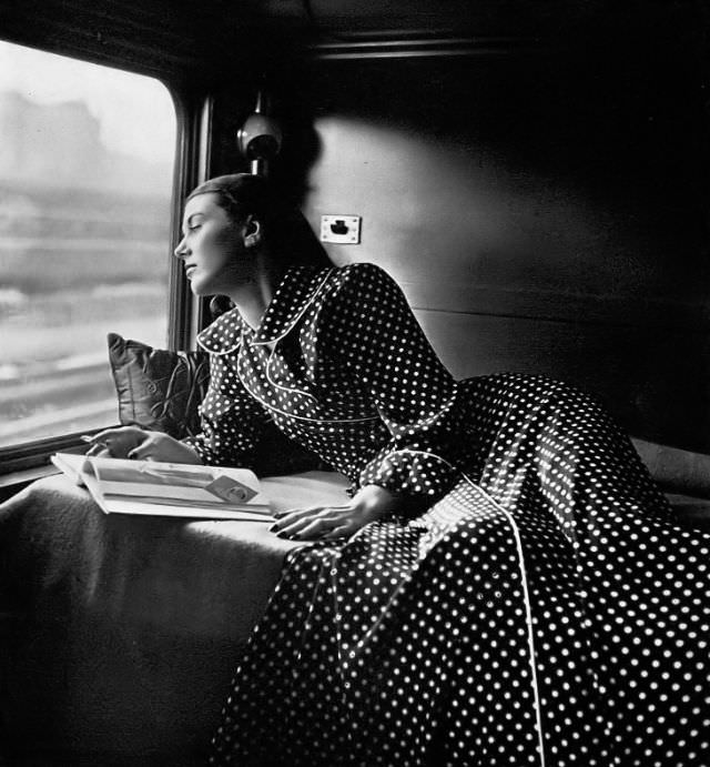 Model in ideal travel robe in navy blue-and-white in sheer rayon with big round collar revers by Raymodes, Harper's Bazaar, 1947.