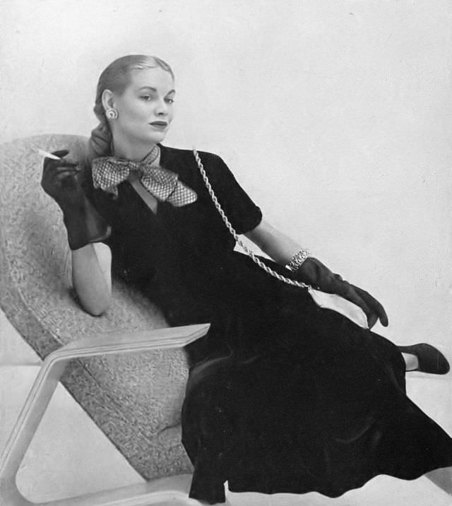 Natalie Paine in soot-black velveteen dress fastens at the side with shirring at the right shoulder by Aywon, worn with big taffeta bow by Emily Wetherby, Harper's Bazaar, 1947.