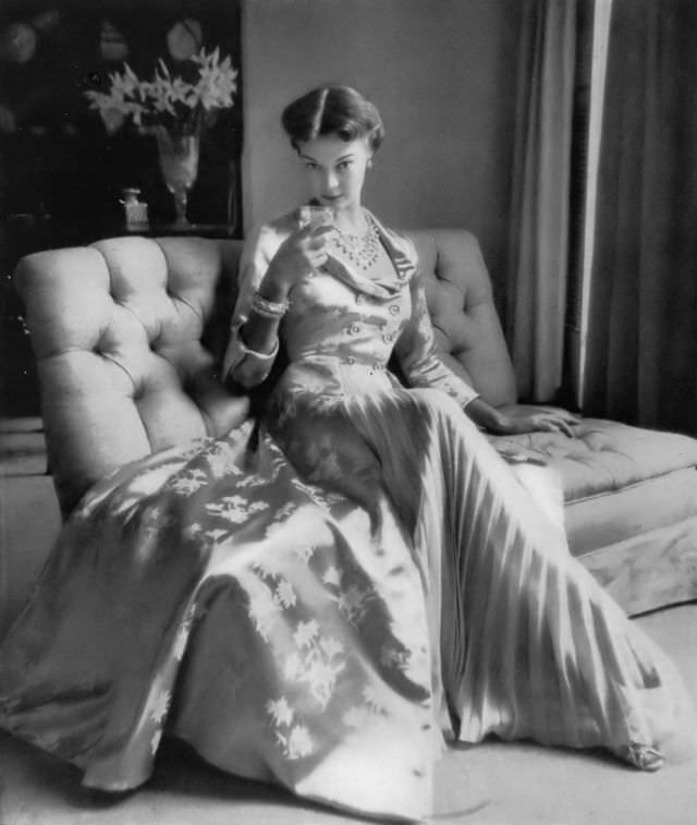 Jean Patchett in tea-and-twilight coat of imported rayon brocade with cut-away pleated panel of silk chiffon from Bergdorf Goodman, Vogue, 1949.