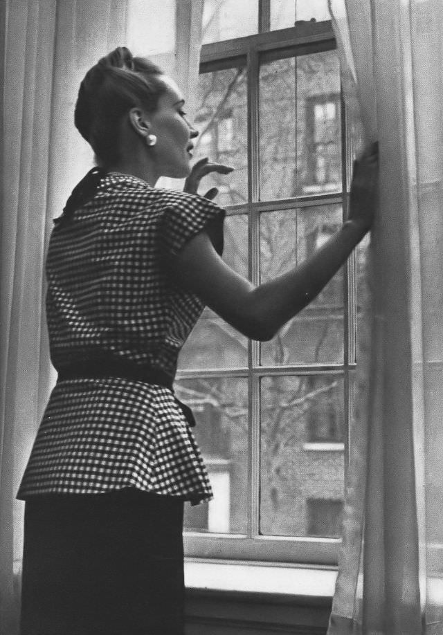 Model in black-and-white checked gingham ripple peplum top over straight black rayon skirt at Bloomingdale, Vogue, 1945.