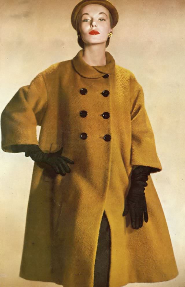 Liz Pringle in Forstmann's amber wool topcoat with loosely folded collar and double-breasted buttons by Harry Frechtel, September 1951