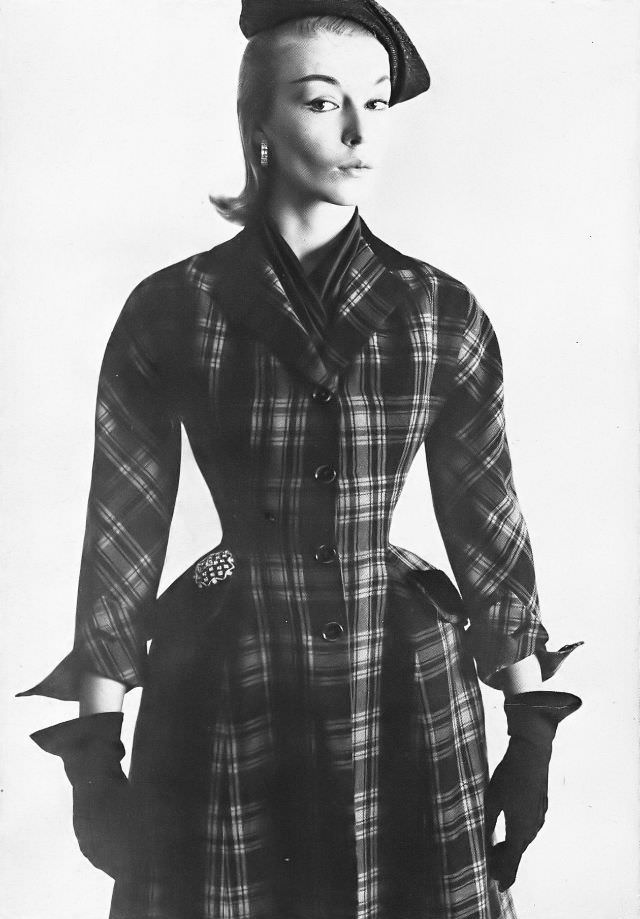 Liz Pringle in fitted, plaid coat of red and black wool, side-swing black straw hat, all by Christian Dior-New York, February 1952