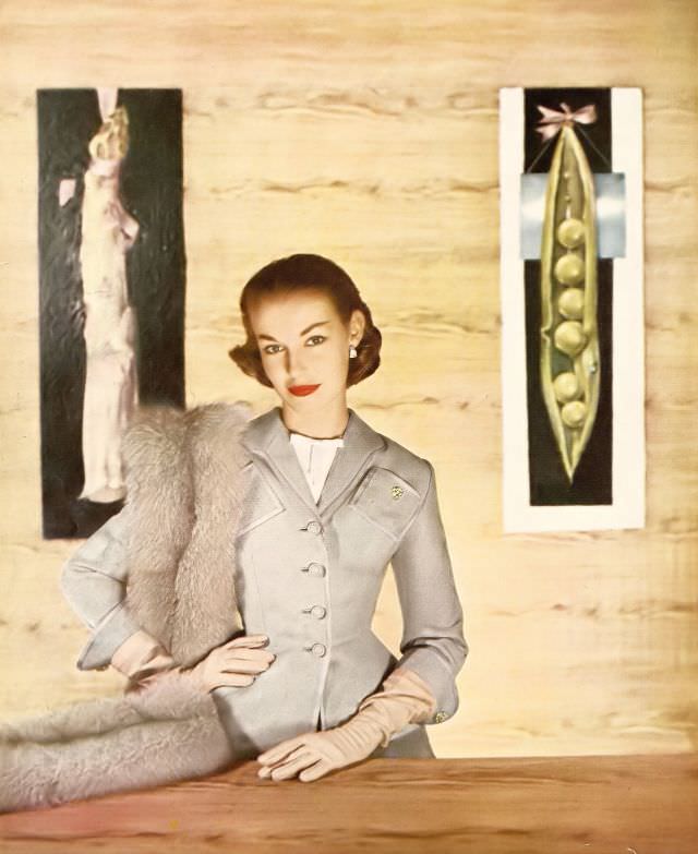 Liz Pringle in narrow, pale gray flannel suit by Lilli Ann, white linen gilet by Emily Wetherby, Harper's Bazaar U.S., February 1952
