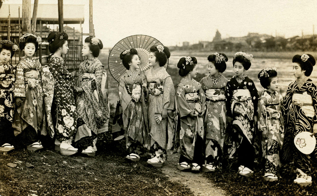 A group of Maiko girls standing on the riverbank, late 1910s