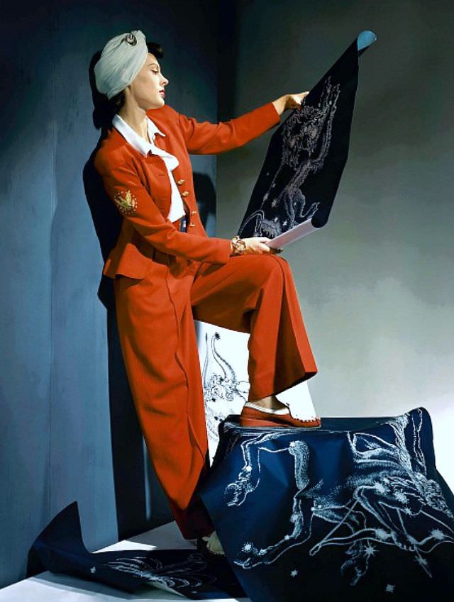 Meg Mundy in red wool slack suit emblazoned with eagle figure, with white shirt and white turban, Vogue 1940