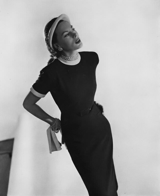 Meg Mundy in black wool jersey dress with white edging at cuffs and collar, Vogue, February 15, 1947