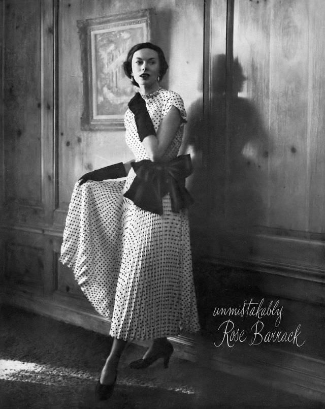 Meg Mundy in black dotted silk dress entirely covered with sequins, with full pleated skirt tied at the waist in large black bow, by Rose Barrack, Harper's Bazaar, February 1948