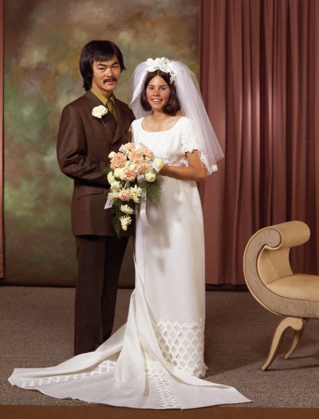 Wedding portrait of Fred Chow and Catherine Choquette. The groom is on the left and wearing a green shirt with a brown suit and tie. The bride is on the right and is wearing a long white dress, August 1971