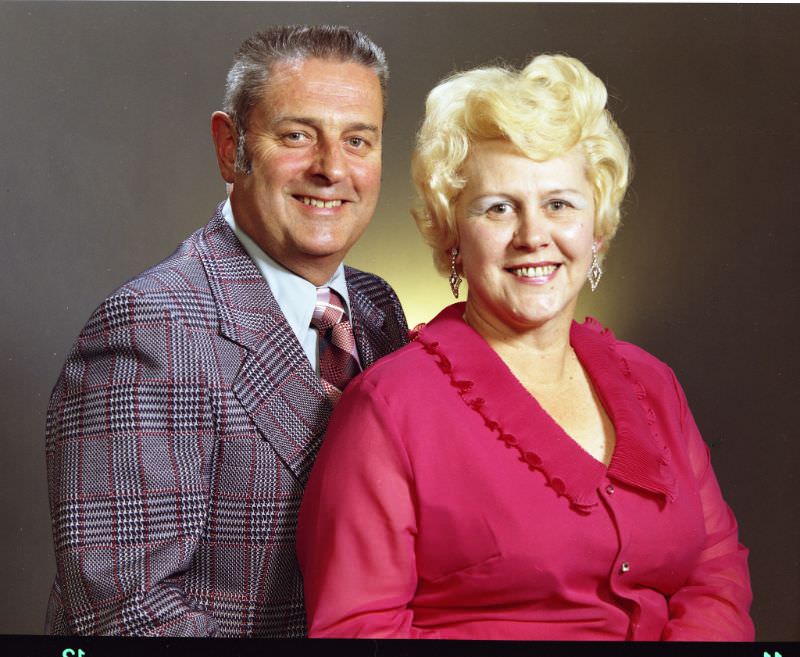 Portrait of a couple. The man is on the left and is wearing a plaid sports coat over a white shirt and plaid tie. The woman is on the right and is wearing a pink top, and dangle earrings, October 26, 1974