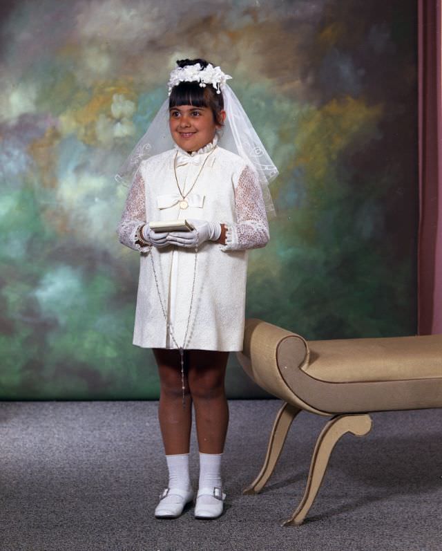 Leonard Maida. She is wearing a short white dress, white veil, and white gloves, holding a book and prayer beads, June 12, 1970