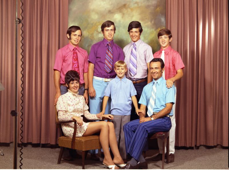 Mother and father are seated on chairs. Four young male figures are standing behind, and a young boy with blonde hair, August 30, 1971