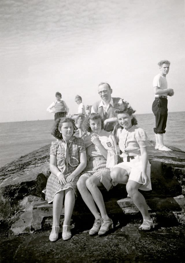A group of middle-class holidaymakers posing at the seaside.