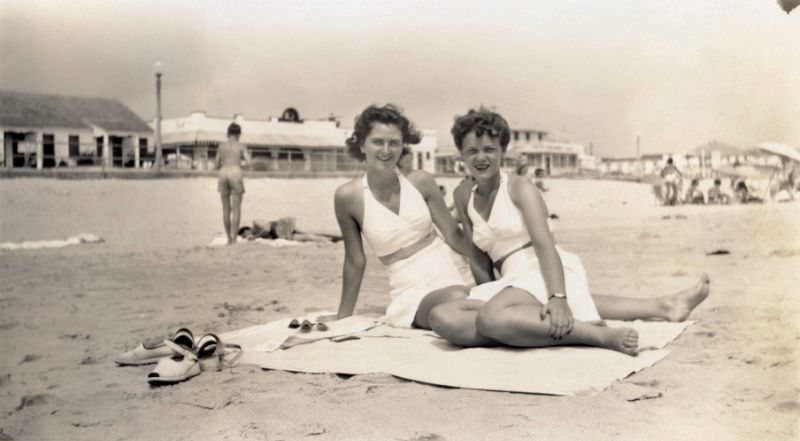 Two young ladies in white swimsuits enjoying a day at the seaside, 1948