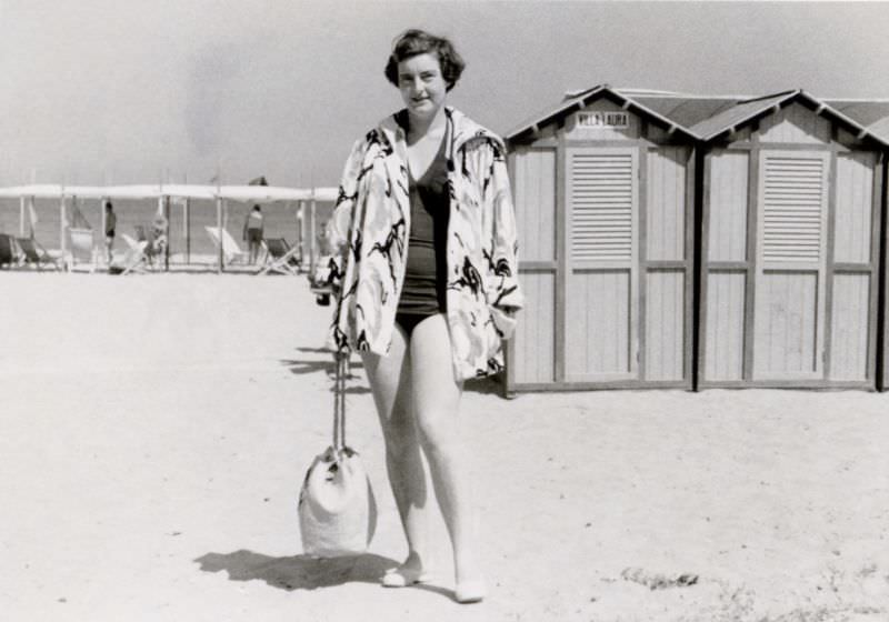 A brunette lady posing on a beach in mid-day sunshine, 1958