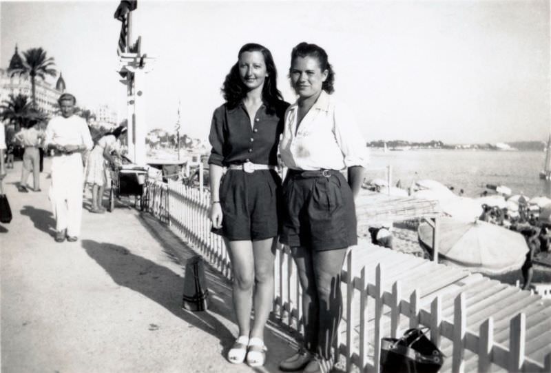 Two young ladies posing on a seaside promenade in the town of Cannes on the French Riviera, 1950s