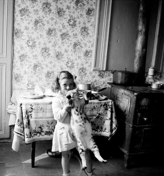 Girl holding cat in East End habitat, Rouen, September 1951