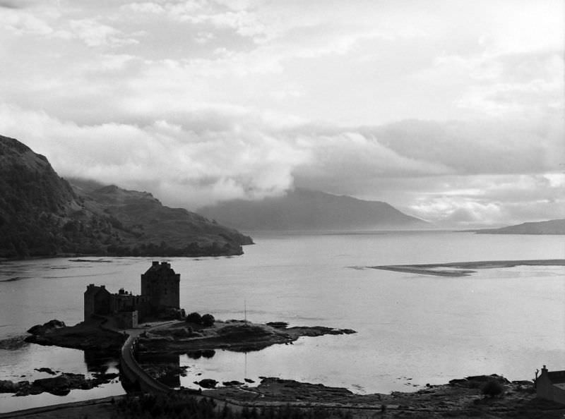 Eilean Donan Castle guarded Loch Duich in the western Highlands near Dornie. Under the low cloud (right) lay the Isle of Skye, to which Prince Charlie once fled, disguised as the serving maid of Scottish Heroine Flora Macdonald. The castle was wrecked by British gunfire in 1719 when it was a headquarters for Spanish and Scottish leaders in one of t