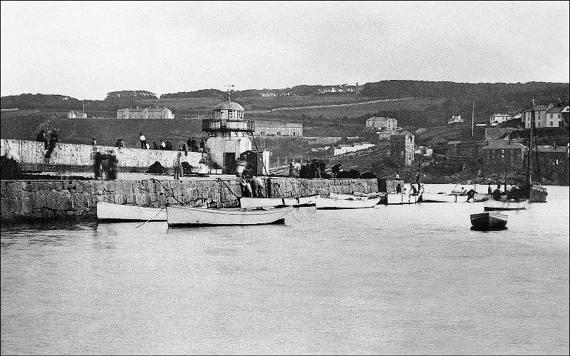 A view of Smeaton's Pier at high water. The Pedn Olva mine engine house can be clearly seen as well as the Malakoff (the disused engine house was used an artists studio for a period), St. Ives, Cornwall