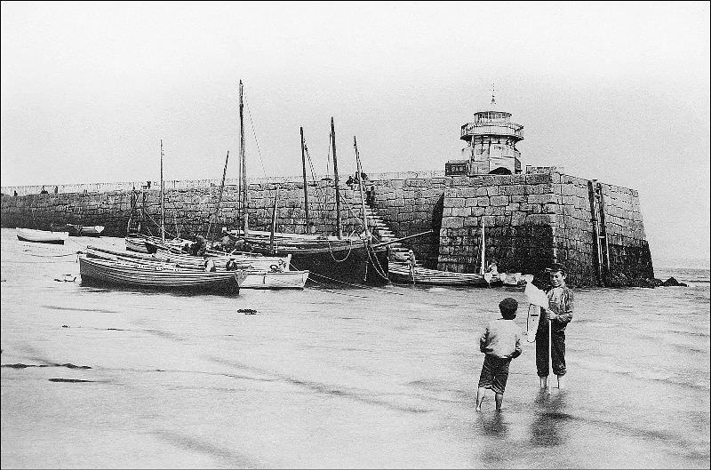 A view of Smeaton's Pier at low tide with a couple of local lads, St. Ives, Cornwall