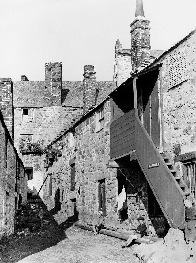 Somewhere in the maze of streets 'Downalong'. The occupier of the building on the right is A.J. Pazolt (Alfred Joseph Pazolt). He was a marine artist, St. Ives, Cornwall