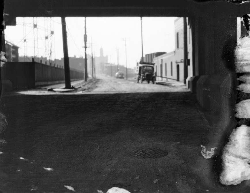 West view of Gratiot Street from beneath 14th Street, gasometer frame on the left and Interior Linseed Co. on the right. National Brewery of Independent Breweries Co. tower in the center distance, 1925