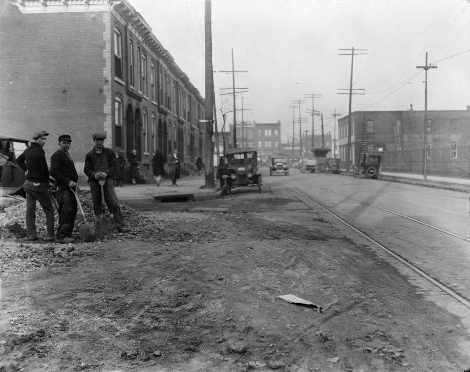 Street crew posing for camera holding shovels near a pile of rubble at the intersection of Evans Avenue and North Sarah Street, 1925