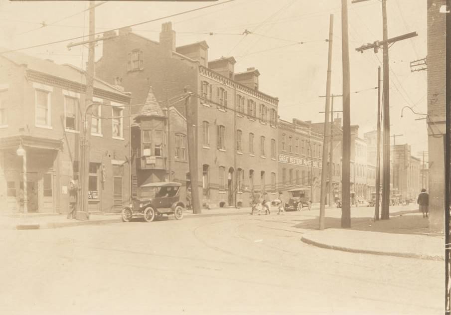 Buildings near the intersection of 14th and Wash streets, with a policeman using a call box on the street corner, 1920
