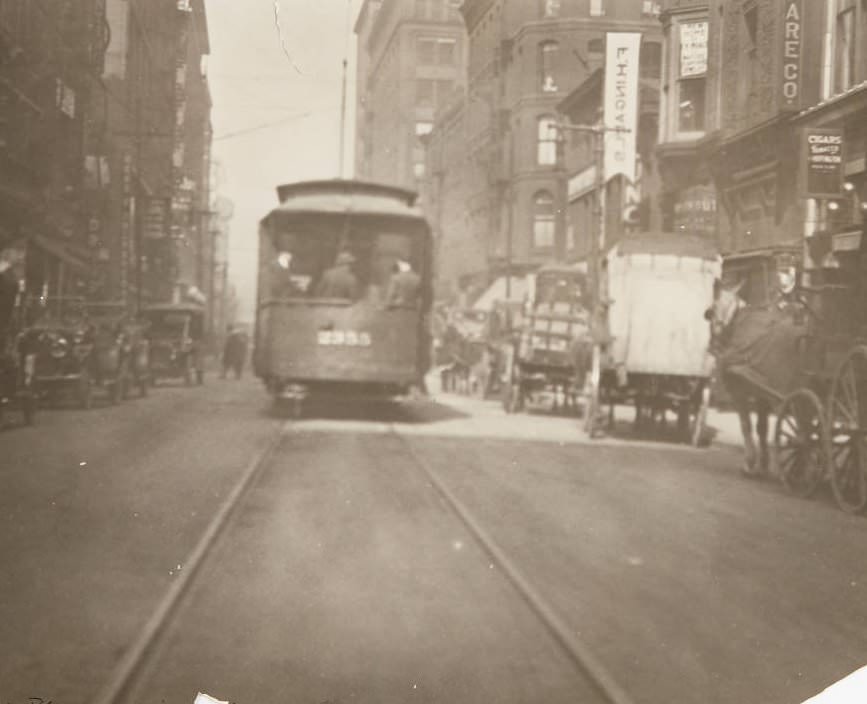 Streetcar and horse-drawn carts moving along 7th Street near Olive, 1920