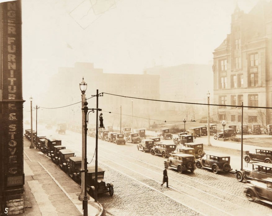 View of 12th Street looking south from Walnut Street, with part of City Hall visible across the street and numerous cars parked along the street, 1920