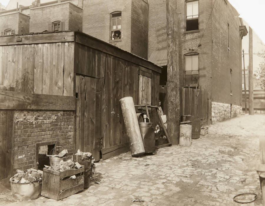 Small wooden building and debris in an alley near Grand Avenue during "Clean up" week, 1920