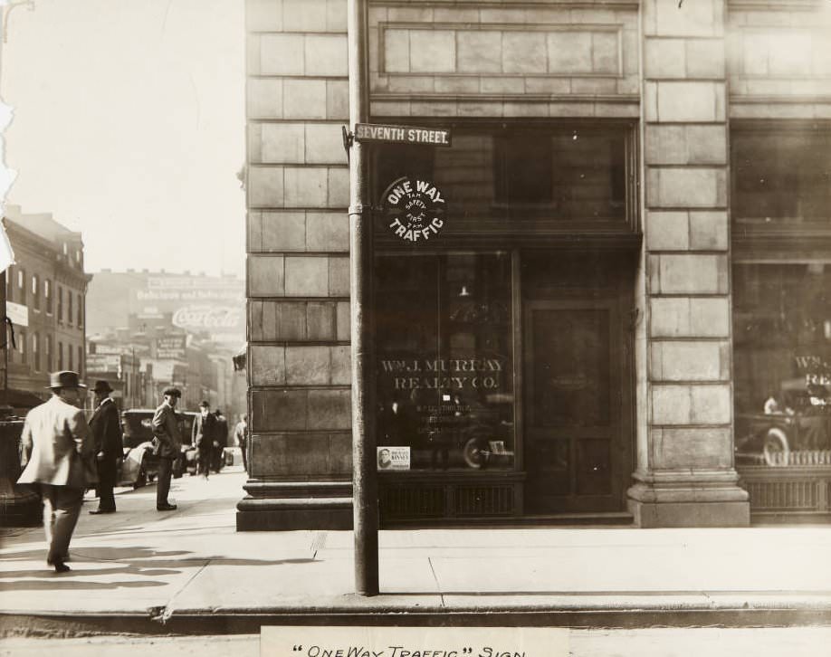 Traffic sign near Seventh and Market Streets with Wm. J. Murray Realty Co. storefront in the background, 1920