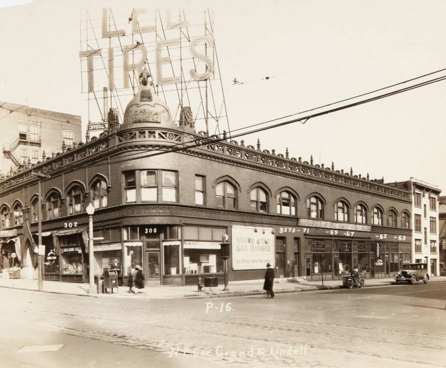 Marina Building at 306 N. Grand at its intersection with Lindell with Grand Garcia Cigar, Lee Tires, and Jay Long Laundry storefronts, 1920