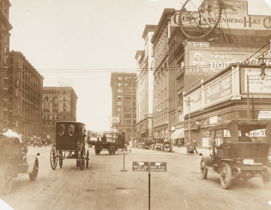 12th and Locust Street, looking north with numerous cars and delivery trucks in traffic and parked along the street, 1920