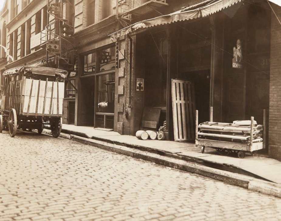 Horse-drawn delivery cart parked in front of a business near the intersection of Fourth and Vine Streets with a spiral staircase fire escape visible behind the cart, 1920