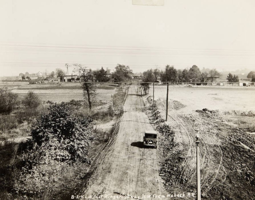 An automobile driving along an unfinished section of East Kingshighway in 1920.