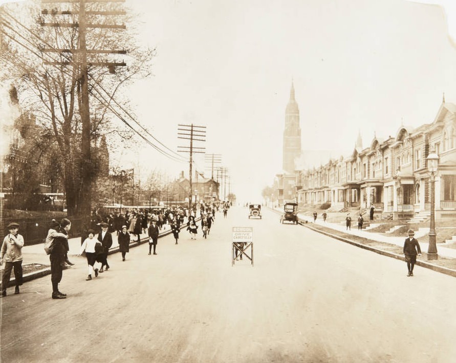 Schoolchildren leaving Hempstead School after a long day of classes in the 5800 block of Minerva Street in 1920. St. Barbara's Church can be seen in the distance.