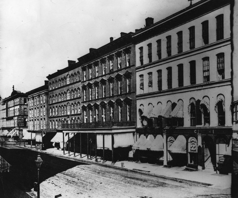 The east side of Fourth street between Olive and Locust, showing the Everett House, Pingee & Brown, Prop., with the upper veranda and iron railing which formed a hotel's trademark, 1949