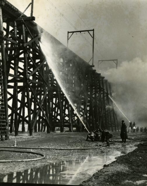 Fire destroying a 300-foot stretch of the Illinois Terminal Railroad trestle at the east approach to McKinley Bridge, 1949.
