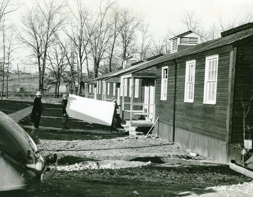 Men carrying white board into a house at Jefferson Barracks, date unknown.