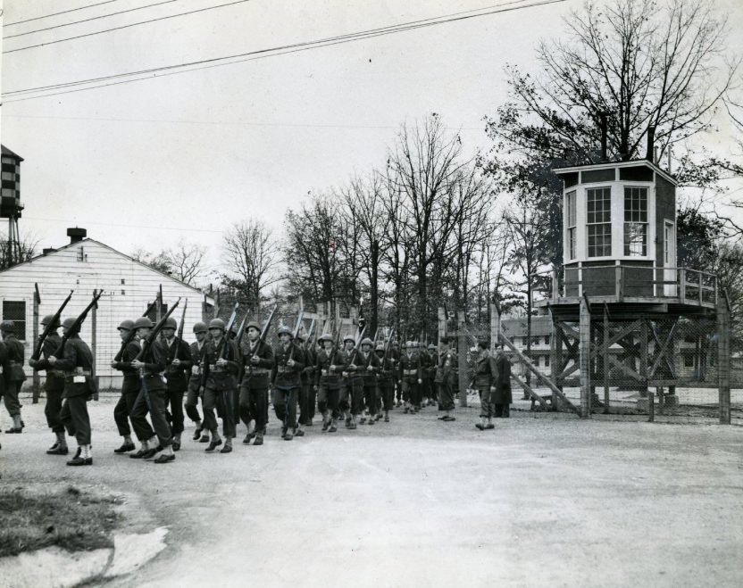 From Behind A Barricade And In The Shadow Of A Guard Tower March Soldiers Who Are Confined, 1944