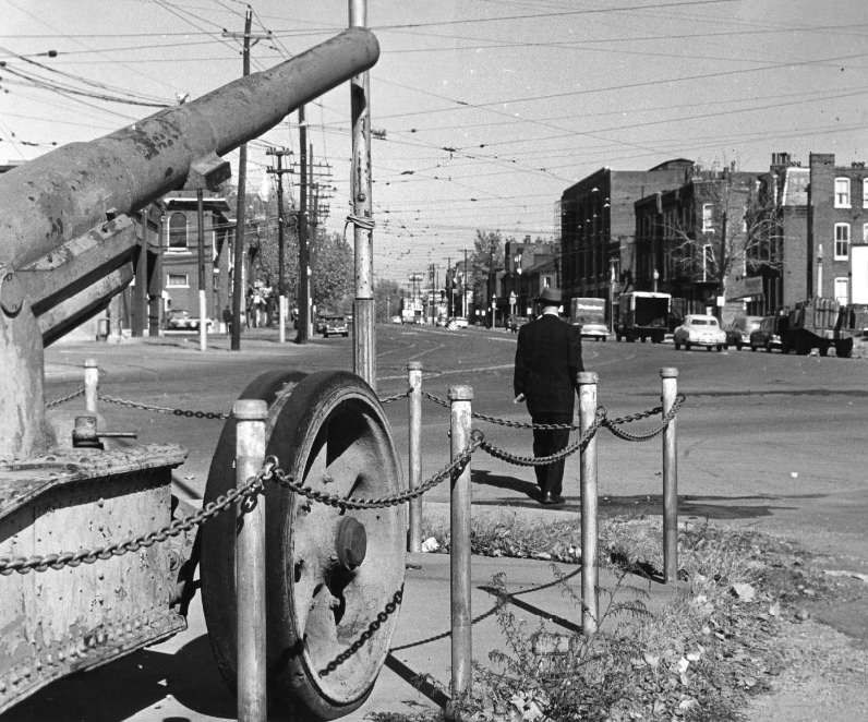 Old cannon from World War I alarms small public area where Broadway curves slightly at Gasconade, 1956