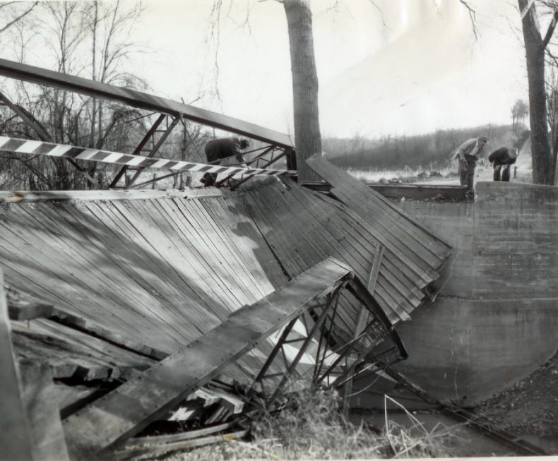 Boards and girders hang crazily after this one-lane bridge on Old Baumgartner road over Mattese Creek in south St. Louis, 1955